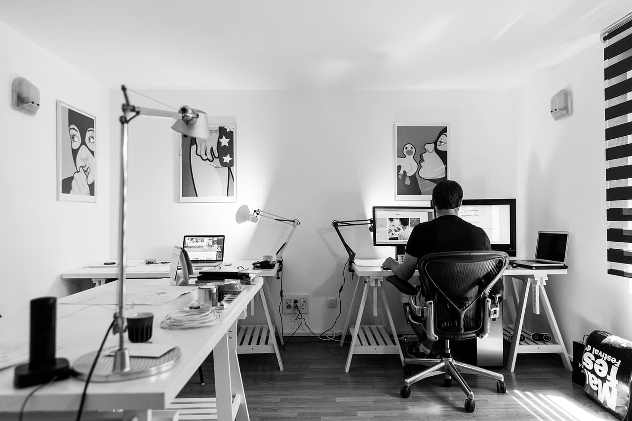 A designer's workstation lit by its monitors
